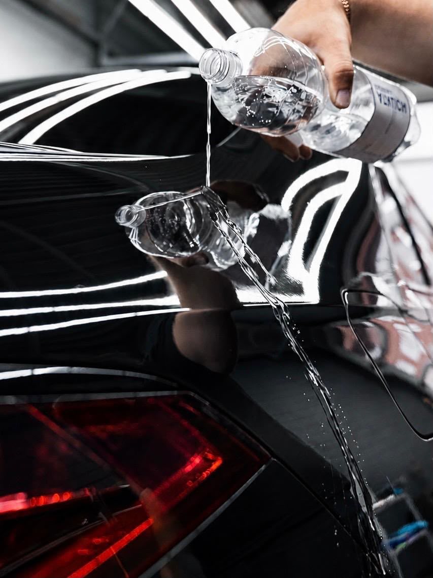 Wasser perlt auf schwarzem Fahrzeuglack nach Keramikversiegelung bei AUTO MULA in Wohlen AG