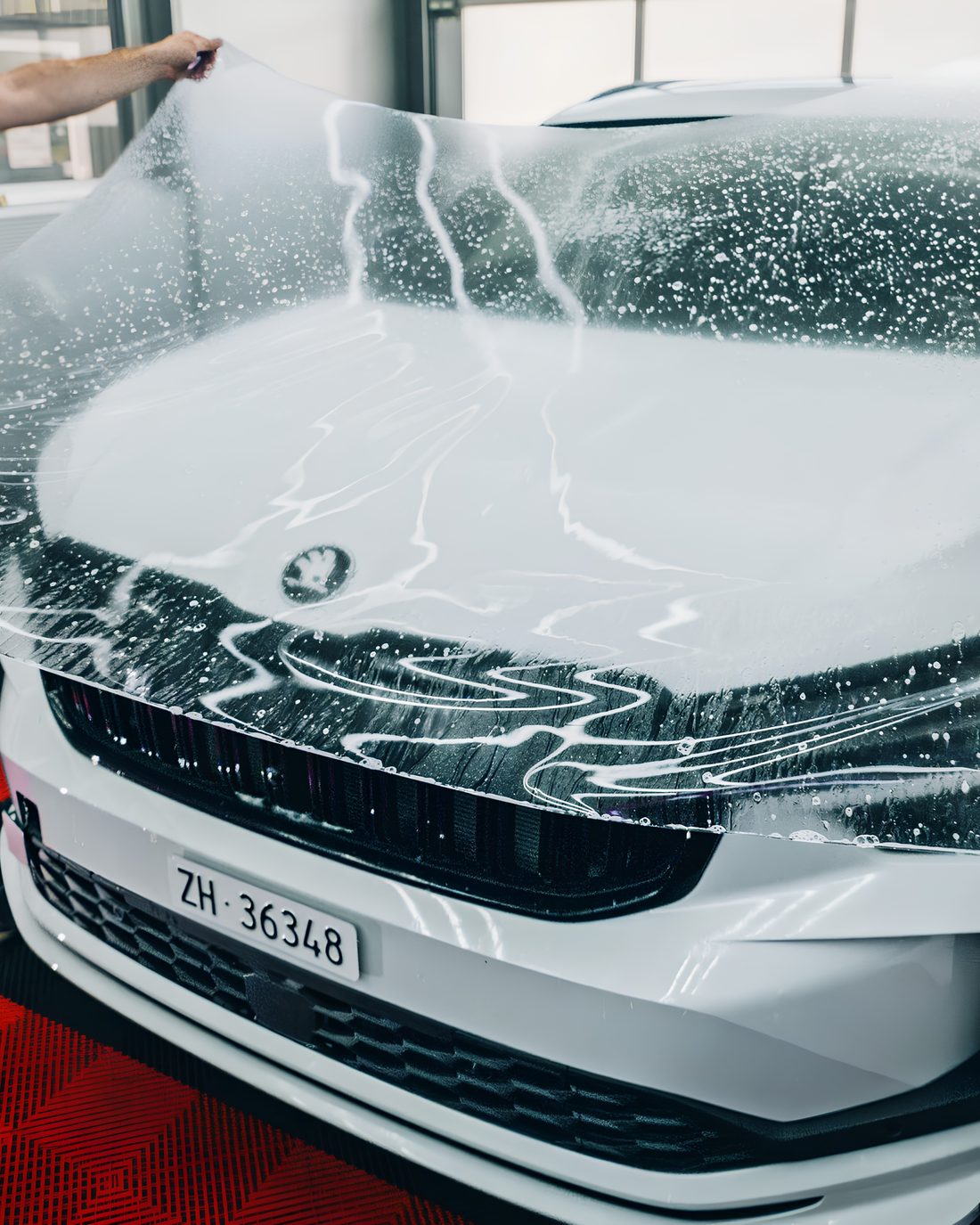 PPF Lackschutzfolie wird auf die Fronthaube eines Fahrzeugs aufgebracht bei AUTO MULA in Wohlen AG